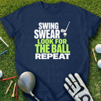 Navy t-shirt with "Swing Swear Look for the Ball Repeat" text and golf accessories.