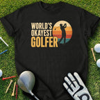 Black t-shirt with "World's Okayest Golfer" text and sunset graphic.