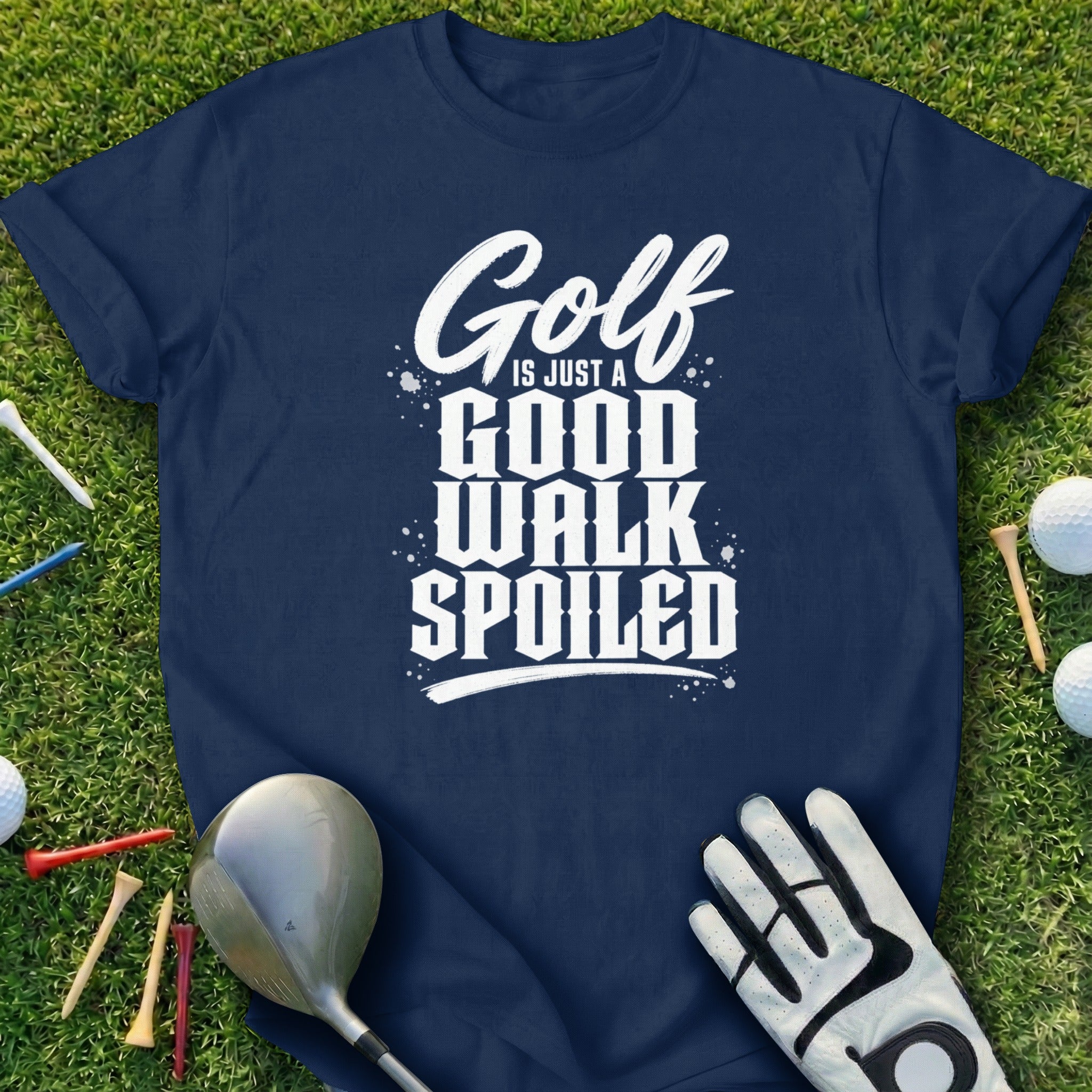 Navy t-shirt with "Golf is Just a Good Walk Spoiled" text on grass.