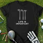 Black t-shirt with white golf club graphics and "LIFE IS IMPORTANT" text.