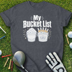 Dark t-shirt with "My Bucket List" graphic showing golf balls and beer bottles in buckets.