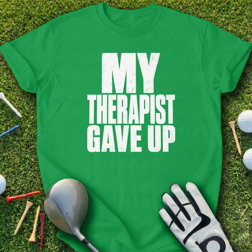 Green t-shirt with "MY THERAPIST GAVE UP" text, golf club, glove, and balls.