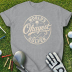 Grey t-shirt with "World's Okayest Golfer" text and golf accessories.