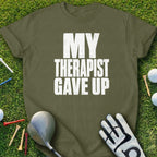 Olive green t-shirt with white text "MY THERAPIST GAVE UP".