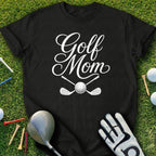 Black t-shirt with "Golf Mom" in white script, golf clubs, ball, tee, and glove.