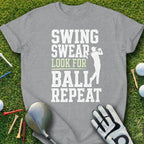 Gray t-shirt with "Swing Swear Look for Ball Repeat" text and golfer graphic.