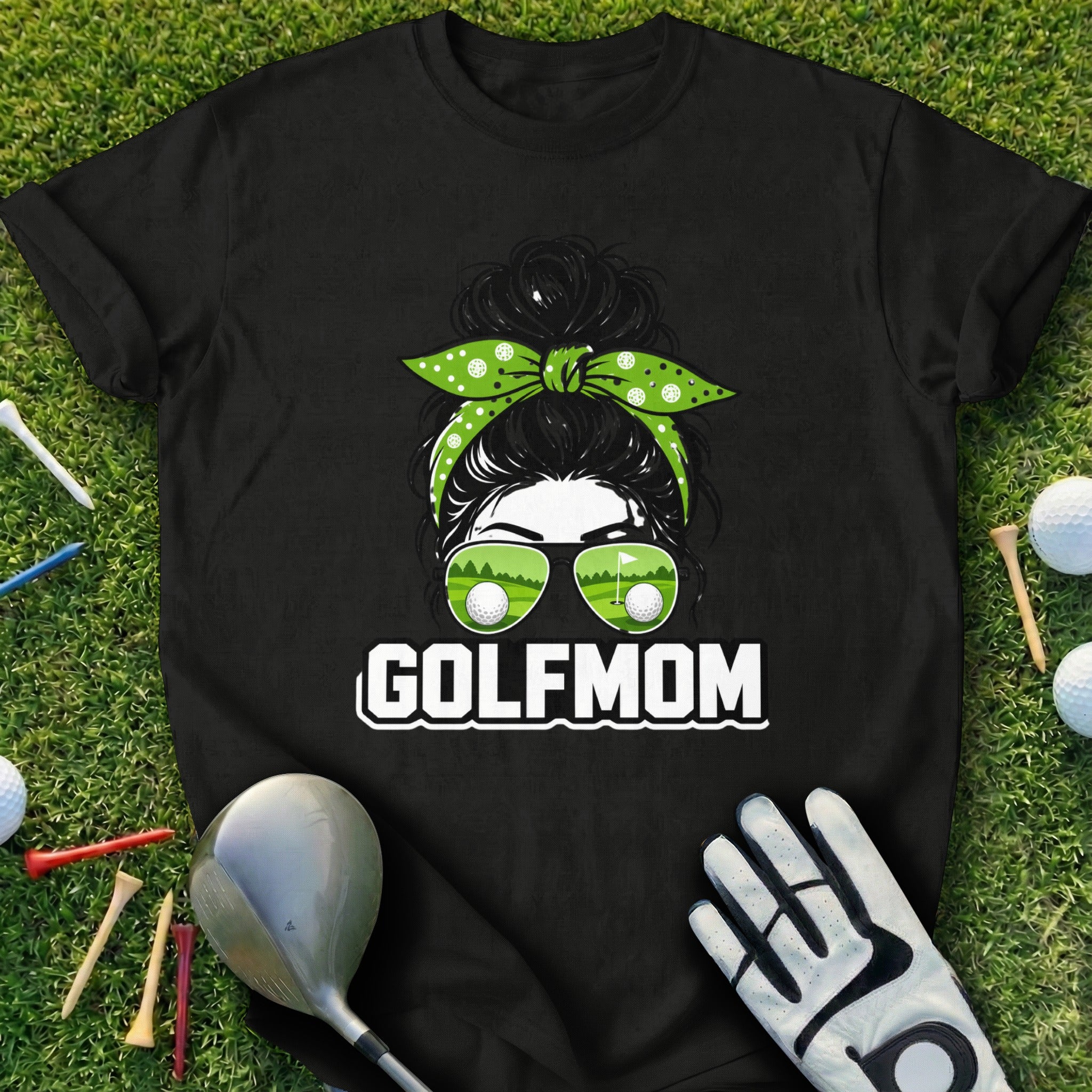 Black t-shirt with "GOLF MOM" text and a woman's face with golf balls in sunglasses.